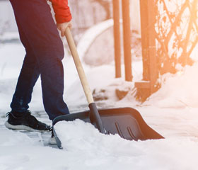 Persona recogiendo nieve con una pala